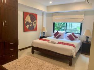 a bedroom with a large bed and a window at The Sands : 3 Bedrooms Naiharn Beachside Apartment in Nai Harn Beach