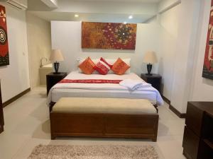 a bedroom with a bed with two tables and two lamps at The Sands : 3 Bedrooms Naiharn Beachside Apartment in Nai Harn Beach