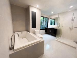 a bathroom with a tub and a toilet and a sink at The Sands : 3 Bedrooms Naiharn Beachside Apartment in Nai Harn Beach
