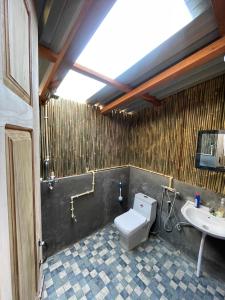 a bathroom with a toilet and a sink at Chimney Farmstay in Kurseong