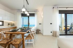 - une cuisine et une salle à manger avec une table et des chaises dans l'établissement Mageia Exclusive Residence, à Vederoi