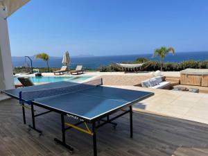 - une table de ping-pong sur une terrasse avec une piscine dans l'établissement Mageia Exclusive Residence, à Vederoi