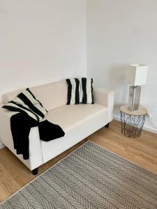 un sofá blanco en una sala de estar con lámpara en Ferienwohnung mit Terrasse und Sauna, en Ortenberg