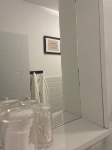 ein weißes Badezimmer mit einem Spiegel und einem Waschbecken in der Unterkunft Garsonieră în complex rezidențial in Bukarest