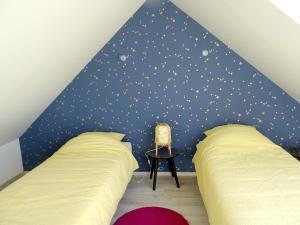 a bedroom with two beds and a blue wall with stars at COTE CIEL - CANCALE - GITE STANDING - PROCHE CENTRE ET PORT in Cancale