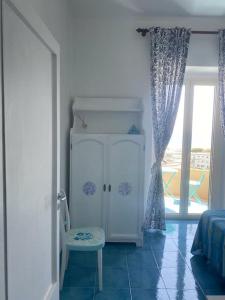 a room with a cabinet and a chair and a window at I datteri Bilocale ristrutturato a meno di 300 mt dal mare in Gaeta