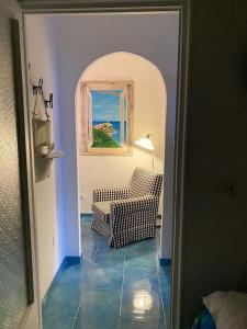 a living room with a chair and a window at I datteri Bilocale ristrutturato a meno di 300 mt dal mare in Gaeta