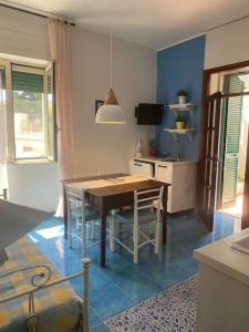 una cucina con tavolo e sedie in una stanza di I datteri Bilocale ristrutturato a meno di 300 mt dal mare a Gaeta