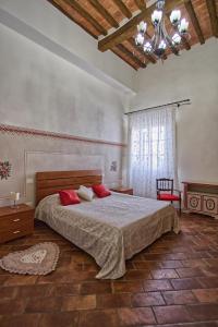 Borgo Creativo-A casa di Anna-Appartamento Mosaico. في مونتوبولي في فال دارنو: غرفة نوم بسرير كبير ومخدات حمراء