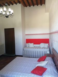 瓦爾迪安諾蒙托波利的住宿－Borgo Creativo-A casa di Anna-Appartamento Mosaico.，一间卧室配有两张带红白色枕头的床
