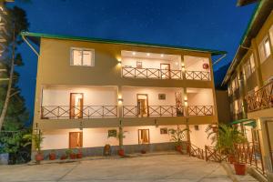 Resorts By The Baagh, Bhimtal في بهيمتال: عمارة سكنية مع شرفة في الليل