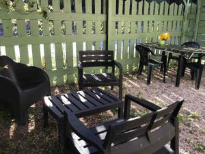 a group of black chairs and tables in front of a fence at Appartement Vert, Compreignac in Compreignac