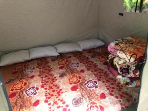 a bed in a room with flowers on it at City Escape Camps and Cafe Kheerganga in Kheerganga