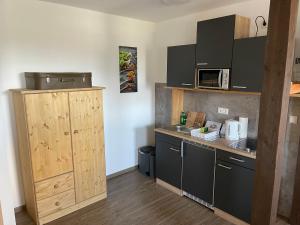 una pequeña cocina con armarios negros y encimera en Jennys Hofladen en Usedom Town