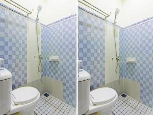 baño con 2 aseos y azulejos azules en OYO 90978 Khalifi Guesthouse Syariah en Padang