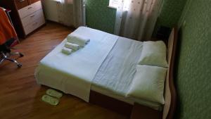Una cama con sábanas blancas y toallas. en Colchis ca777, en Kutaisi