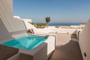 a swimming pool on the side of a house at North Wind Luxury Suites in Oia