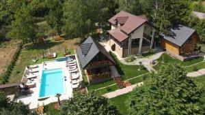 une vue aérienne d'une maison avec piscine dans l'établissement Apartmani Joka i Drvene kucice, à Vrdnik