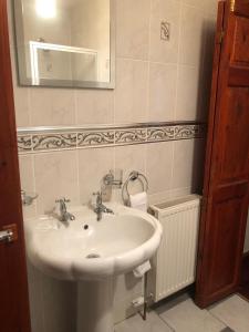 a bathroom with a white sink and a mirror at Executive Serviced Apartments 1 in Forfar