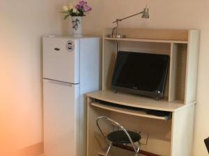 a small kitchen with a refrigerator and a tv at Executive Serviced Apartments 1 in Forfar