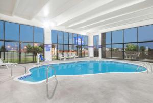 ein großer Pool in einem Gebäude mit Fenstern in der Unterkunft Baymont by Wyndham Springfield South Hwy 65 in Springfield