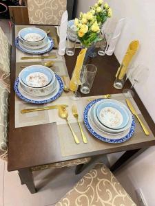 a table with blue and white plates and utensils at Romantic Studio Unit, Matina Enclaves Residences in Davao City