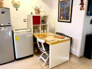 uma pequena cozinha com uma mesa e um frigorífico em Cozy & Full Apt in Coyoacan Great for Long Stays em Cidade do México