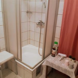 um chuveiro na casa de banho com um lavatório e uma mesa em Fassbinder Klause mit Mini-Terrasse em Sankt Veit an der Glan