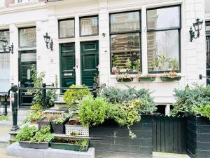 a house with green doors and potted plants at Flinder Amsterdam in Amsterdam