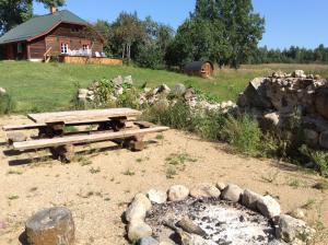 a picnic table and a fire place in a field at Kossa Tarõ 