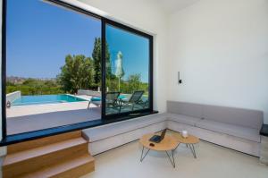 a living room with a couch and a table and a pool at Fairytale Villas in Souda