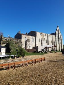 Saint-Hilaire-la-Palud的住宿－AU COEUR DU MARAIS，一座大城堡,前面有一堆长椅