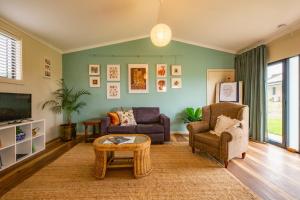 sala de estar con 2 sillas y TV en Meander Retreat - Garden Studio en Springton