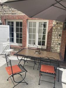 - une table de pique-nique et des chaises devant un bâtiment en briques dans l'établissement Maison Etretat à 50 mètres de la plage, à Étretat