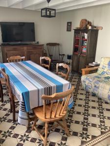 uma sala de estar com uma mesa e cadeiras e uma televisão em Maison Etretat à 50 mètres de la plage em Étretat