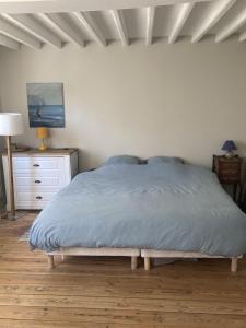 um quarto com uma cama com um cobertor azul em Maison Etretat à 50 mètres de la plage em Étretat
