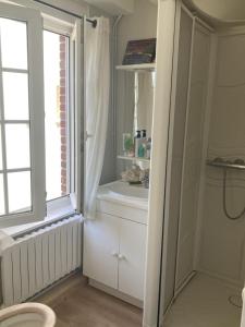 a bathroom with a sink and a window at Maison Etretat à 50 mètres de la plage in Étretat