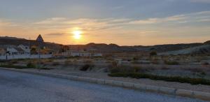 a sunset in the desert with a road and houses at Villa Preciosa in Camposol