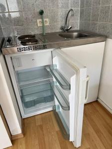 La cuisine est équipée d'un évier et d'un réfrigérateur ouvert. dans l'établissement kleines Apartment im Zentrum von Würzburg, à Wurtzbourg