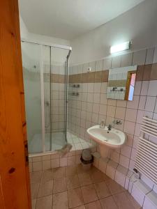 a bathroom with a shower, sink, and toilet at Katalinkert Panzió in Győr