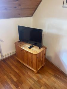 a tv sitting on top of a wooden stand in a room at Katalinkert Panzió in Győr