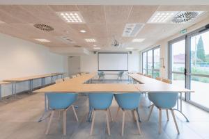 una gran sala de conferencias con una mesa grande y sillas en Ibis Budget Mont De Marsan en Mont-de-Marsan