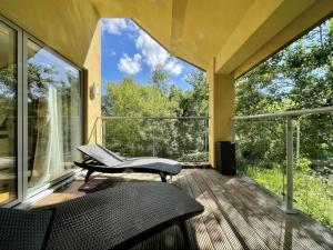 um alpendre com uma cadeira e uma mesa em Modern contemporary home in beautiful setting em Somerford Keynes