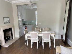a dining room with a white table and chairs at Stylish 3-bedroom flat in Kensington in London