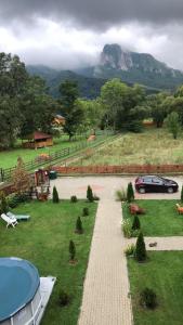 a car parked in a yard with a mountain in the background at Cabana Sweetlife in Rimetea