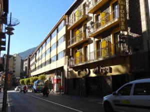 a building on the side of a city street with cars at Hostal Cal Forner in Andorra la Vella