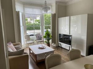 - un salon avec un canapé, une table et une cheminée dans l'établissement Stylish 3-bedroom flat in Kensington, à Londres