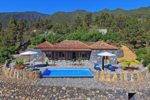 a villa with a swimming pool and a house at Casa El Vendaval in Tijarafe