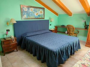a bedroom with a blue bed and a painting on the wall at Hotel Lion in Roure Turin