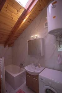 een badkamer met een wastafel, een toilet en een bad bij Όμορφη σοφίτα 5λεπτά από το κέντρο της πόλης in Ioannina